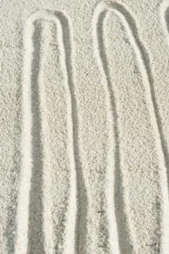 Squiggly pattern drawn in sand Foto stock
