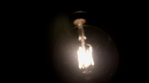 Squirrel cage filament light bulb, retro glow bright trendy globe swinging in Stock Footage 89194525