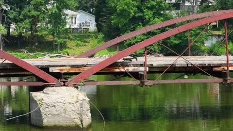 Squirrel running across an old red metal bridge over Rock River Stock Footage 340926148