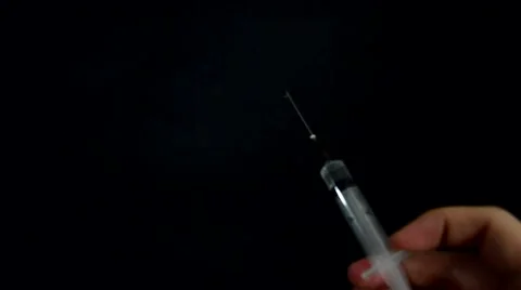 Squirting the medicine from a syringe on a black background Stock Footage 59447824