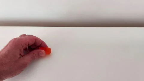 Squish Satisfaction: Hand Presses Vibrant Orange Jelly Candy Close-Up Vidéo 319981153