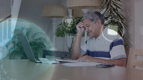 Sr man reading papers rubbing head noting bills using laptop globe icons moving Stock Footage 334338109
