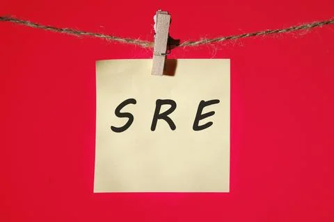 SRE. Site Reliability Engineering text on a yellow sticker hanging on a rop.. Stock Photos