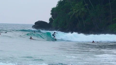 SRI LANKA - CIRCA 2017: Young surfers trying to ride waves at the tropical beach Video stock 84778731