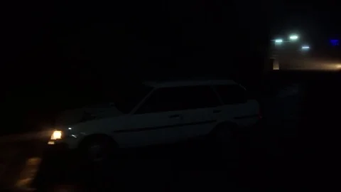 SRI LANKA, ELLA CIRCA 2017: A car with headlights passing on a dark foggy road Stock Footage 76941245