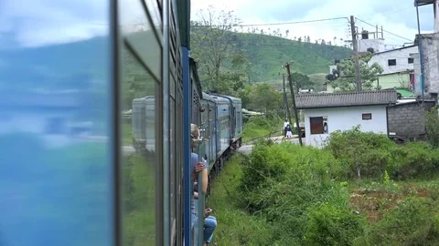 Sri Lanka - Hanging from train as it moves through mountain village Stock Footage 73424322