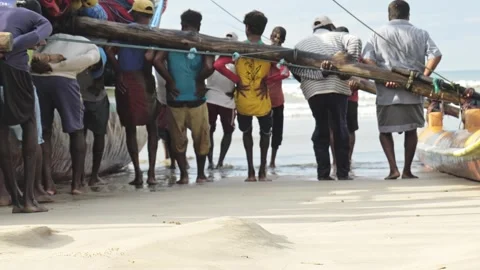 Sri Lankan Fishermen Pulling Large Wooden Fishing Boat onto Beach Stock Footage 337058532