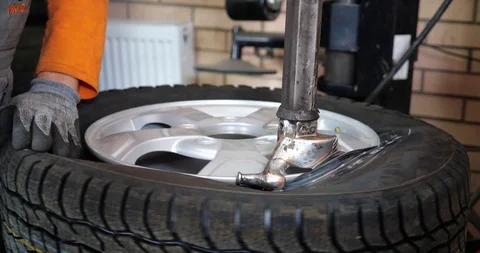 Sservice Man put on tyre on car wheel by special tool, mechanic using mounting Stock Footage 101387796