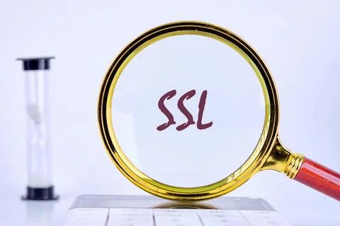 SSL Secure Sockets Layer through a magnifying glass on a gray background next Fotos Stock