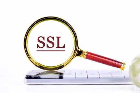 SSL Secure Sockets Layer through a magnifying glass on a calculator on a ligh Fotos Stock