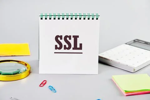 SSL Secure Sockets Layer on a white notepad on a gray background next to offi Stock Photos