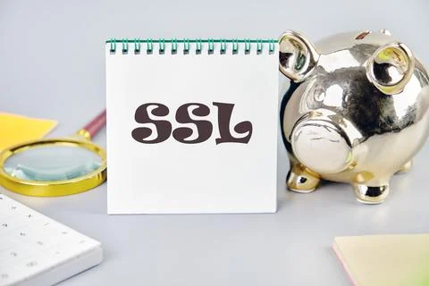 SSL Secure Sockets Layer on a white notebook on a gray background near a pigg Photos