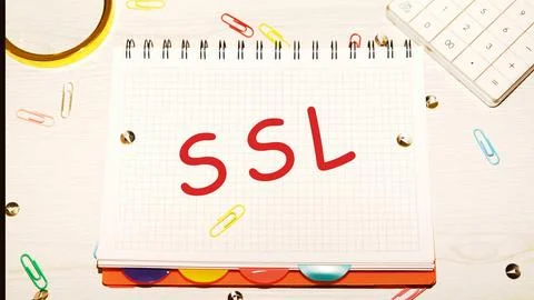 SSL word on a checkered notebook on a light table next to a magnifying glas.. Photos
