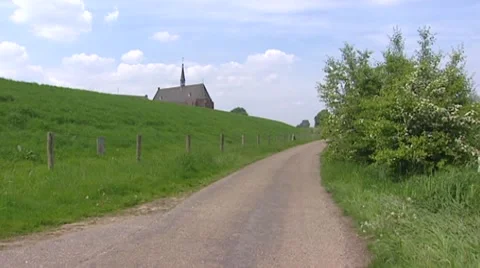 St. Agatha monastery behind river dike + pan floodplains River Meuse Stock Footage 41769627
