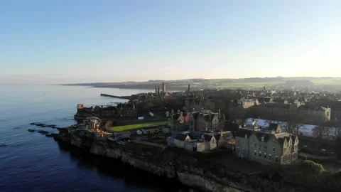 St Andrews aerial along coastline over sea during hightide, sunny day Stock Footage