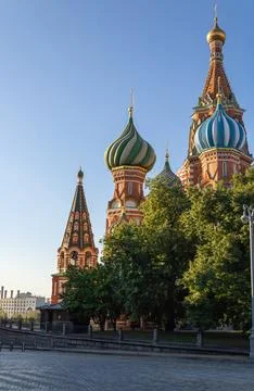 ! St. Basil's Cathedral. Trees, cobbled street. Blue cloudless sky. Moscow. Stock Photos
