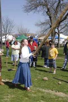 ST. CHARLES, UNITED STATES - Apr 05, 2009: A young woman tosses a caber pole  Stock Photos