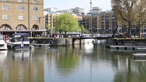 St Katharine's Dock on a spring day with people walking over a bridge Stock Footage 132071249