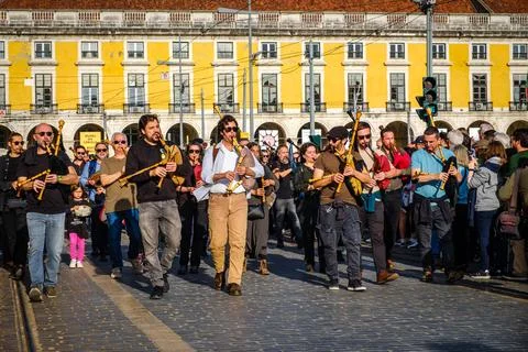 St Patrick bagpipers parade in Praca do Commercio on sunny day Stock Photos