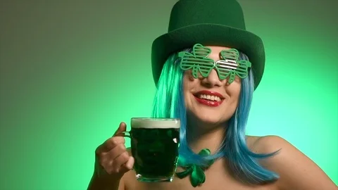 St. Patrick's Day. Leprechaun model girl with pint of green beer Stock Footage 102633100