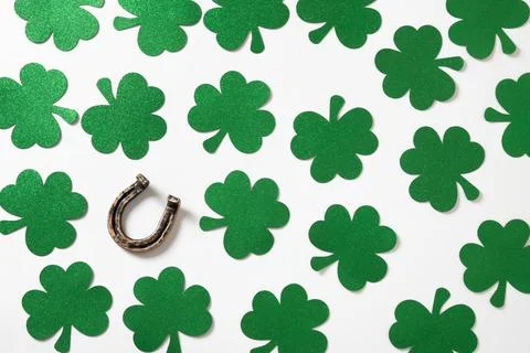St. Patrick's day pattern with clover leaves and horseshoe on white. Stock Photos