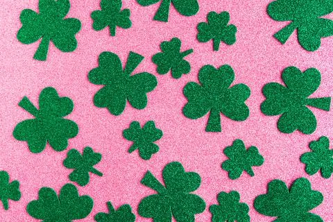 St. Patrick's Day pattern paper shamrocks on pink glitter background. Foto stock