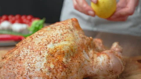 Stabbing a lemon and placing it into a whole raw chicken in 4k. Stock Footage 145111327