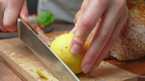 Stabbing a lemon and placing it into a whole raw chicken in 4k. Stock Footage 145111915