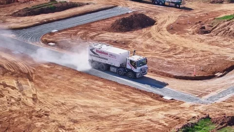 Stabiiser bringing up dust as it compacts a new road in construction site Stock Footage 277968193