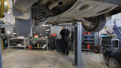 A stabilized camera image in an auto repair shop, the car is lifted on a lift. Stockbeeldmateriaal 256161323