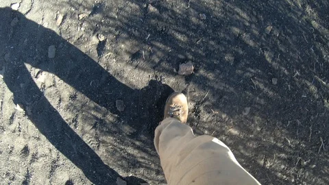 Stabilized camera ponting down to the feet os a man, walking over 스톡 동영상 91519714