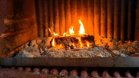 Stabilized footage of a wooden block set on fire in a stone fireplace hearth Stock Footage 201385964