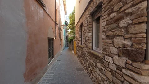 Stabilized forward walk through narrow medieval alley with flowers and vintage d Stock Footage 322099867