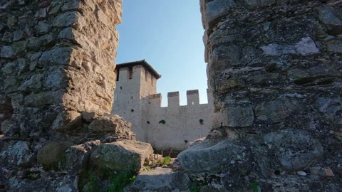 Stabilized left-to-right move of medieval brick walls and tower framed through b Stock Footage 322100966