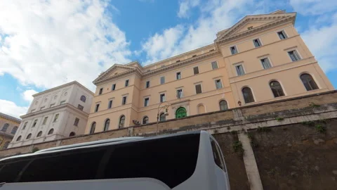 Stabilized low right-to-left walk past old building facade with passing cars Stock Footage 322113207