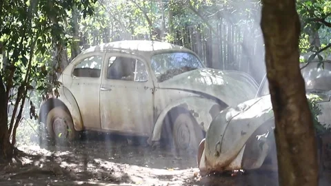 A stabilized shot from light rays through smoke shining over a old beetle waste  Video stock 194396378