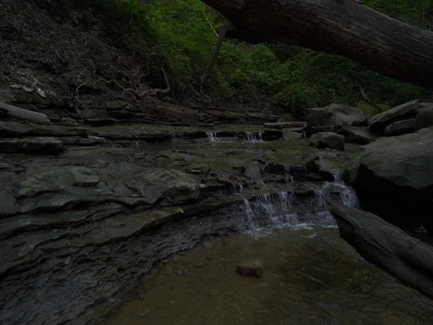Stabilized shot moving over several small cascading waterfalls in Cuyahoga Stock Footage 77104253