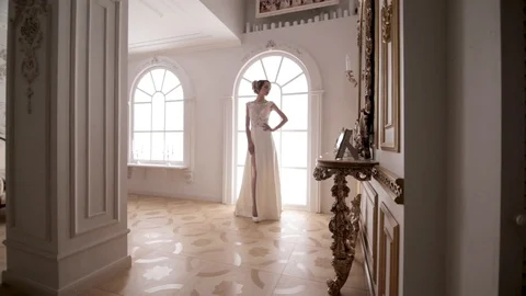 Stabilized shot of young bride standing near window Stockbeeldmateriaal 104576729