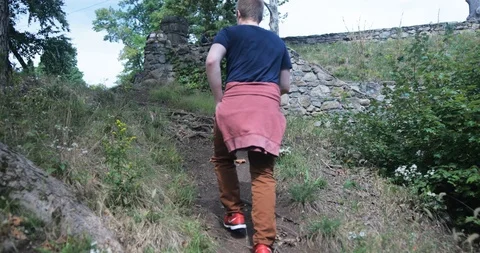 Stabilized tracking medium shot of male hiking to man made waterfall Stock Footage 112140745