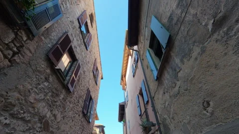 Stabilized upward walk through medieval alley with brick walls and flowers Stock Footage 322109635