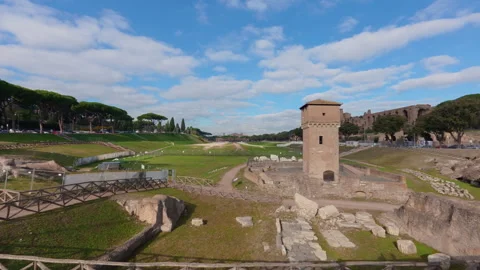 Stabilized wide left-to-right walk across Roman archaeological site and green fi Stock Footage 322114399