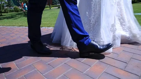 Stabilizer, legs close-up, bride and groom go to the park Stock Footage 99366228
