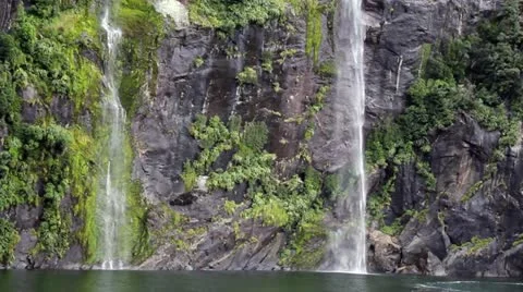 Stable boat shot of a double waterfall at Milford Sound New Zealand Stock Footage 11526396