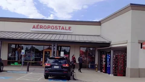 Stable slow motion pan of several outlet mall storefronts on partly cloudy day 库存影片 165254025