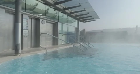 Stablised tracking shot from changing area to rootop thermal pool in historic Vídeos de archivo 108040260