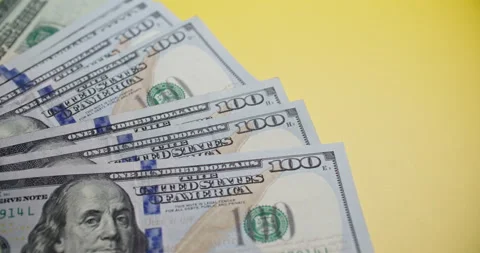 Stack of $100 Bills on Yellow Background - Close-Up Stock Footage 307863007
