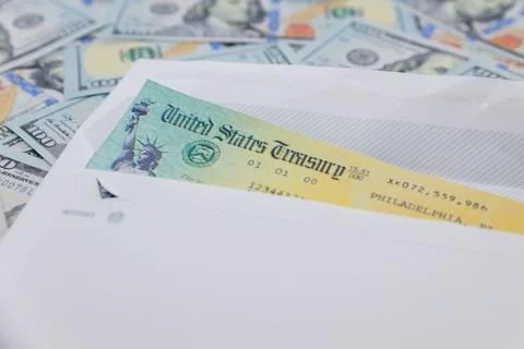 Stack of 100 dollar bills with coronavirus stimulus payment check to show the Stock Photos