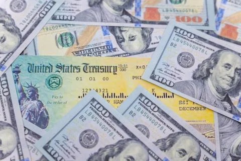 Stack of 100 dollar bills with coronavirus stimulus payment check to show the Stock Photos