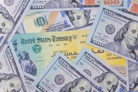 Stack of 100 dollar bills with coronavirus stimulus payment check to show the Stock-Fotos