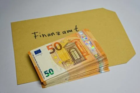 Stack of 50 euro banknotes on envelope labeled Finanzamt German tax office .. Stockfoto's